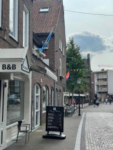 une rue avec un panneau sur le côté d'un bâtiment dans l'établissement MG BB, à Venlo