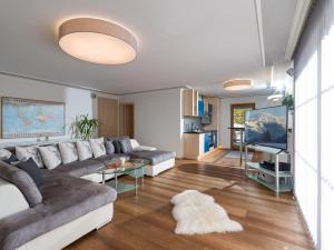 sala de estar con sofá y TV en Chalet Weinberg Top 1 & Top 2 by Apartment Managers en Kirchberg in Tirol