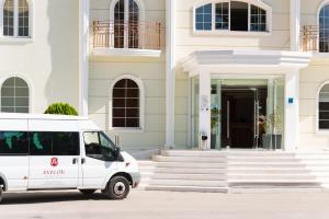 ein weißer Van vor einem Gebäude geparkt in der Unterkunft Avalon Palace Hotel - Adults Only in Zakynthos