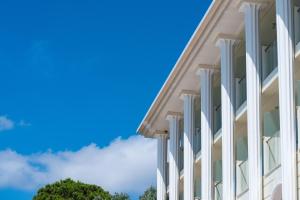 a white building with a blue sky in the background at Avalon Palace Hotel - Adults Only in Zakynthos Town