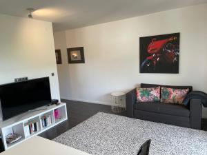 a living room with a couch and a flat screen tv at Schlossblick in Egloffstein