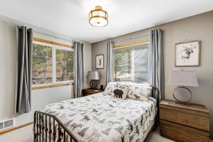 a bedroom with a bed and two windows at McCall Cottage Cabin in McCall
