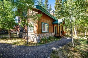 a small wooden house with a porch and a driveway at McCall Cottage Cabin in McCall