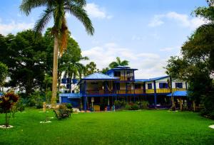 a large house with a palm tree in front of it at Finca Hotel el Edén del Quindío in Calarcá