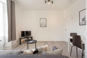 a living room with a couch and a tv at Modern & bright 1 bed for 4 close to city centre! in Edinburgh
