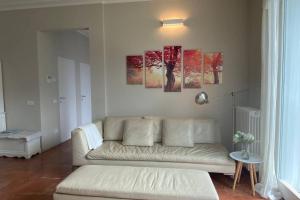 a living room with a white couch and paintings on the wall at i FAGGI ROSSI - RED BEECH TREES in Como