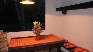 Una pequeña mesa con un jarrón de flores. en Holiday Home Pine Villa, en Pakoštane