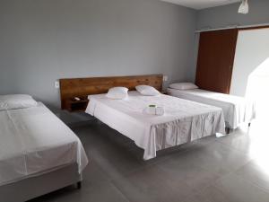 a bedroom with two beds with white sheets at Recanto Filadélfia in Paraty