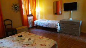 a bedroom with two beds and a dresser and a television at Da Simone podere santi Lucia e Pietro in Siena +22 photos