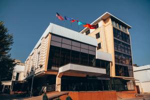 a building with an american flag on top of it at City Hotel Bishkek in Bishkek