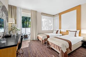 ソポトにあるMolo Residenceのベッド2台とデスクが備わるホテルルームです。