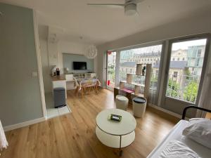 een woonkamer met een bank en een tafel in een kamer bij Studio Morgane-balcon couvert-wifi-près centre-linge et ménage in Reims