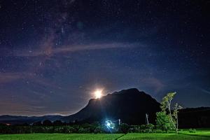 a starry night with a mountain in the background at KraThom Doi Luang in Chiang Dao