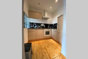 eine Küche mit Holzschränken und Holzboden in der Unterkunft Die kleine Post in Schleiden