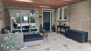 a patio with a couch and a table in front of a house at B&B Margriet in Lemmer