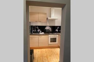 eine Küche mit Holzschränken und Holzboden in der Unterkunft Die kleine Post in Schleiden + 5 Fotos