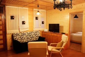 salon z telewizorem, kanapą i krzesłem w obiekcie MI CASA DE MADERA w mieście Paúl