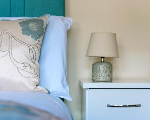 ein Bett mit einem Kissen und einer Lampe auf einem Nachttisch in der Unterkunft Dartry Close in Bundoran