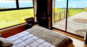 una camera con letto e vista su un portico di El Reflejo Lodge Spa - Queilen - Chiloé a Queilén Altre 37 foto