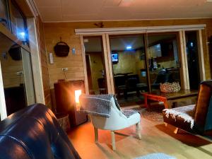 uma sala de estar com um sofá e uma cadeira em El Reflejo Lodge Spa - Queilen - Chiloé em Queilén