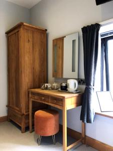 a wooden desk with a chair and a cabinet at Rutland Rooms in Oakham