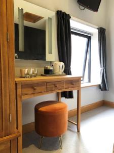 uma secretária de madeira com uma cadeira e uma janela em Rutland Rooms em Oakham