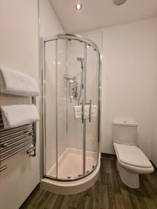 a bathroom with a shower and a toilet at Rutland Rooms in Oakham