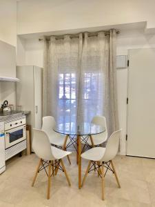 cocina con mesa de cristal y sillas blancas en Centro Madrid Rio - Monederos 48, en Madrid