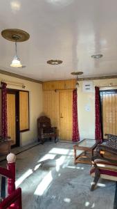 a living room with a table and red curtains at Dilaram Guest House in Srinagar