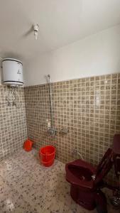 a bathroom with a toilet and buckets in a room at Dilaram Guest House in Srinagar