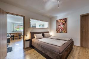 a bedroom with a bed with a painting on the wall at Ferienwohnung Alpenglück in Sankt Jakob in Haus