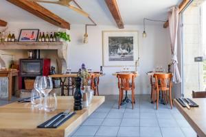 a dining room with tables and chairs and a fireplace at Le Pied de la Lettre in Grignan