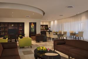 a living room with couches and a dining room at Dreams Jade Resort & Spa - All Inclusive in Puerto Morelos