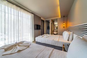 um quarto de hotel com duas camas e uma grande janela em S3 Seahorse Beach Club em Oludeniz