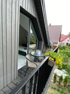 balkon domu ze stołem i łóżkiem w obiekcie Pajūrio Gintaro namai w Połądze