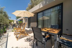 un patio con mesa, sillas y sombrilla en S3 Seahorse Beach Club, en Ölüdeniz