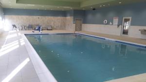 a large swimming pool with blue water in a building at Holiday Inn Express & Suites Tonawanda - Buffalo Area, an IHG Hotel in Tonawanda