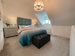 a bedroom with a bed and a chandelier at Newly Developed 3 Bedroom Home in Glasgow