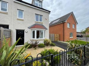 a house with a fence in front of it at Newly Developed 3 Bedroom Home in Glasgow