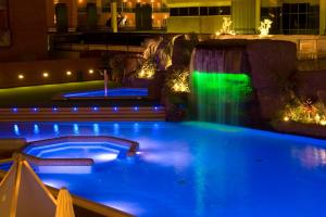 a swimming pool at night with a waterfall at Hotel Papi in Malgrat de Mar