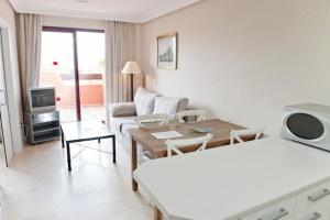 sala de estar con sofá y mesa en Apartamentos Manilva Green en Manilva