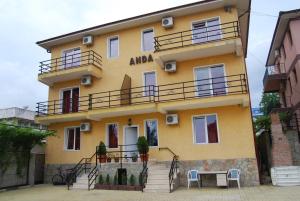 a yellow building with a balcony on the side of it at Vila Anda in Eforie Sud