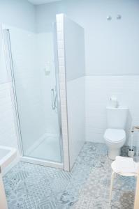 a bathroom with a shower, toilet, and tub at Hotel Smile & Co Hostal Boutique in Alicante