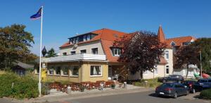 un edificio con una bandera delante de él en Hotel Seeburg, en Sankt Peter-Ording