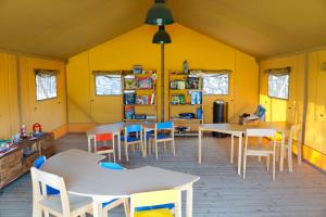 a classroom with tables and chairs in a yellow room at Los Jardines de Abama Suites in Guía de Isora