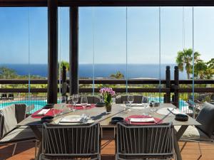 a dining room with a table and chairs at Los Jardines de Abama Suites in Guía de Isora