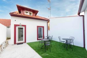 a patio with tables and chairs on the grass at Host'olaria in Lamego