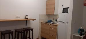 a kitchen with a refrigerator and a counter with stools at ALOJAMIENTO CASA LEÓN in Santoña