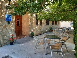 un patio al aire libre con mesas y sillas y un edificio en El Ciervo, en Villaciervos