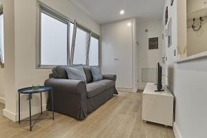 een woonkamer met een bank en een tv bij Malibú Canteras Studio 8 - Playa, WiFi, SmartTV, AC in Las Palmas de Gran Canaria